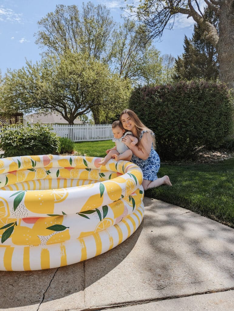 mom and daughter playing by an inflatable pool outdoors