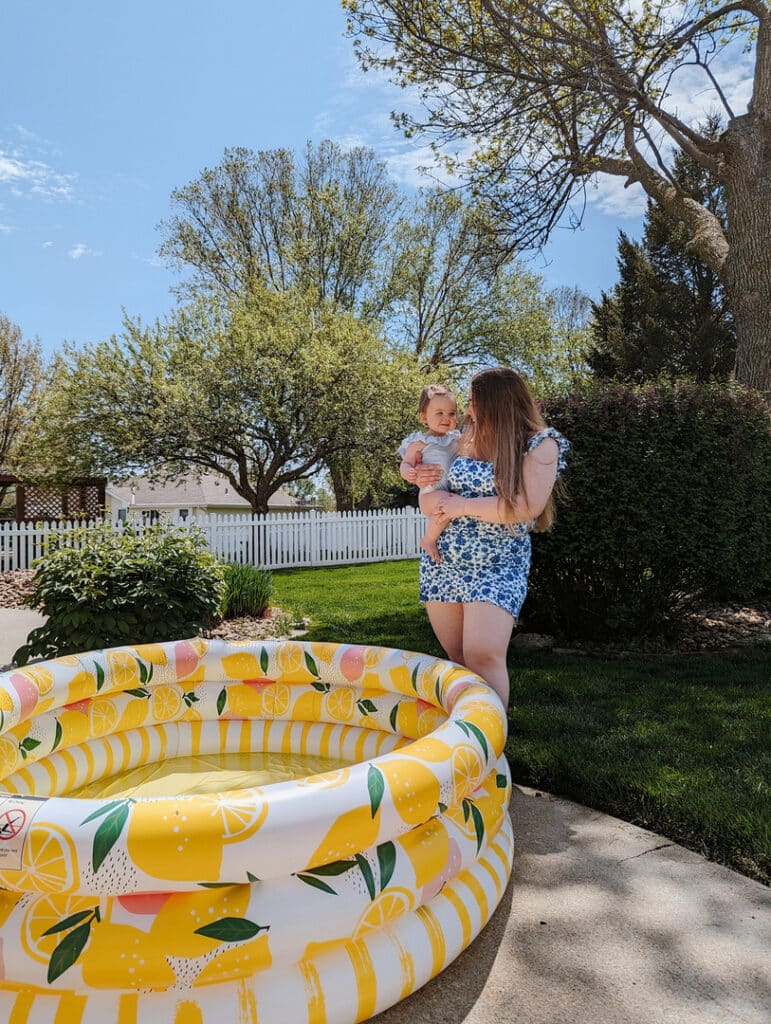 mom and daughter standing by an inflatable pool outdoors